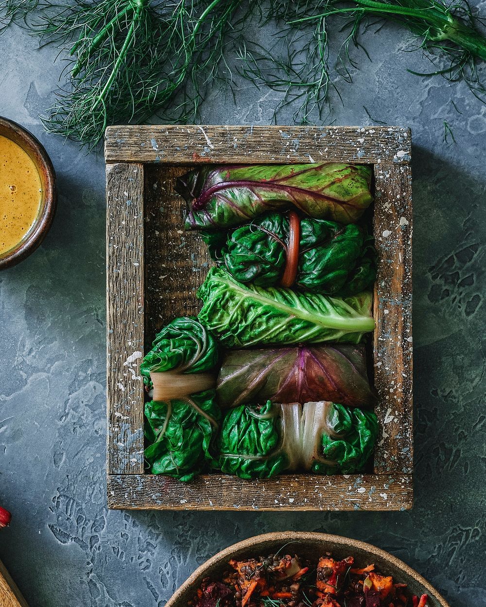 Plant-based green wrap with purple collard kale, cabbage, and chard with turmeric  sauce