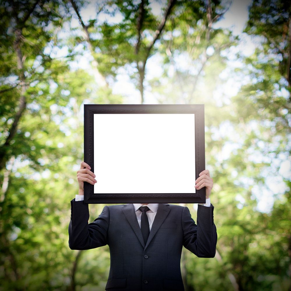 Businessman outdoors holding up a copyspace