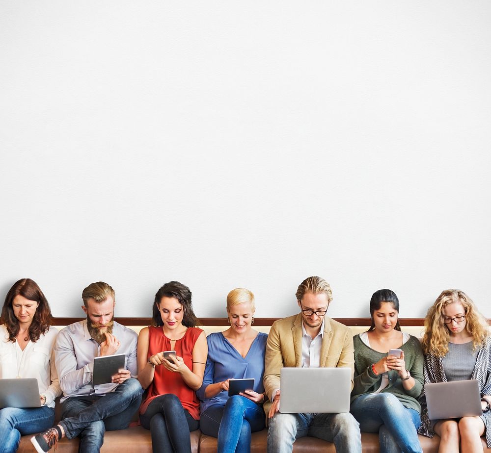 Diverse people in a row on their digital devices