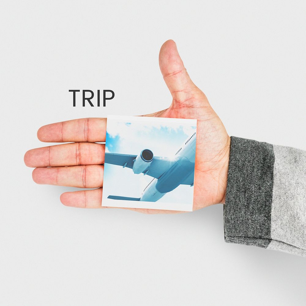 hand holding banner with illustration of air ticket booking for travel destination