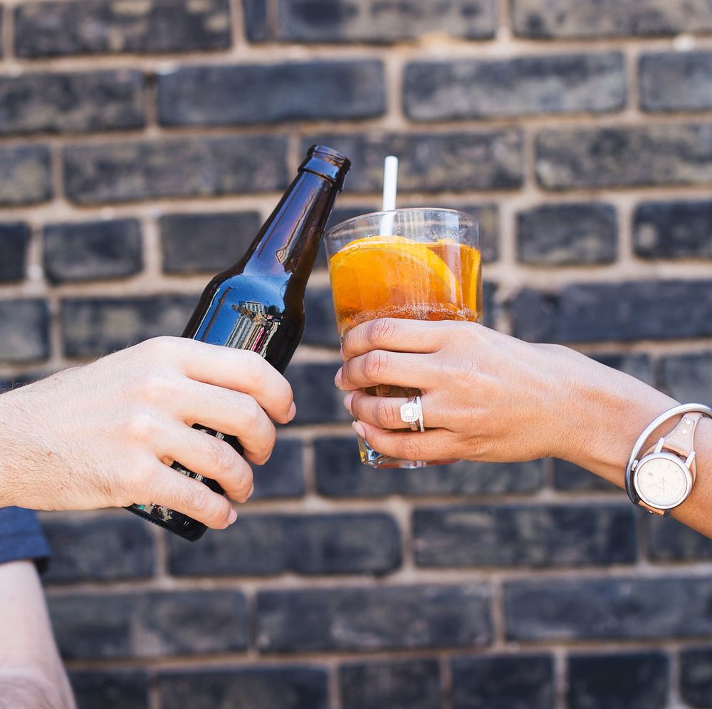 Free hands cheering beer and cocktail brick wall background photo, public domain beverage CC0 image.