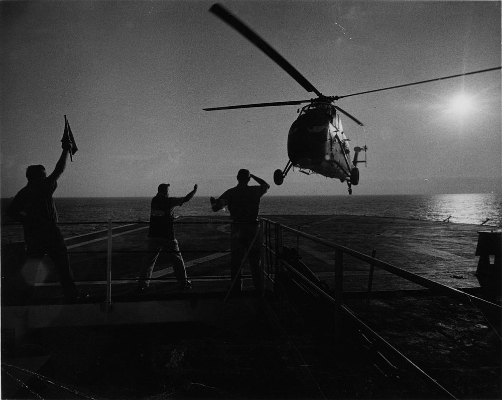 Landing signal officer (center) aboard the Navy Hospital Ship Repose off Vietnam directs a U.S. Marine Helo bringing battle…