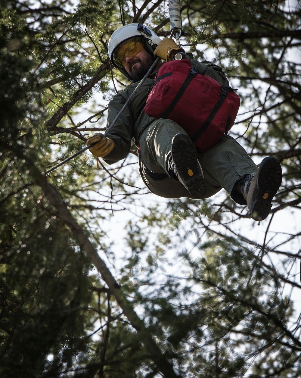 Veteran wildland firefighter rappellers use various techniques to negotiate the wind from the helicopter rotor blades above…