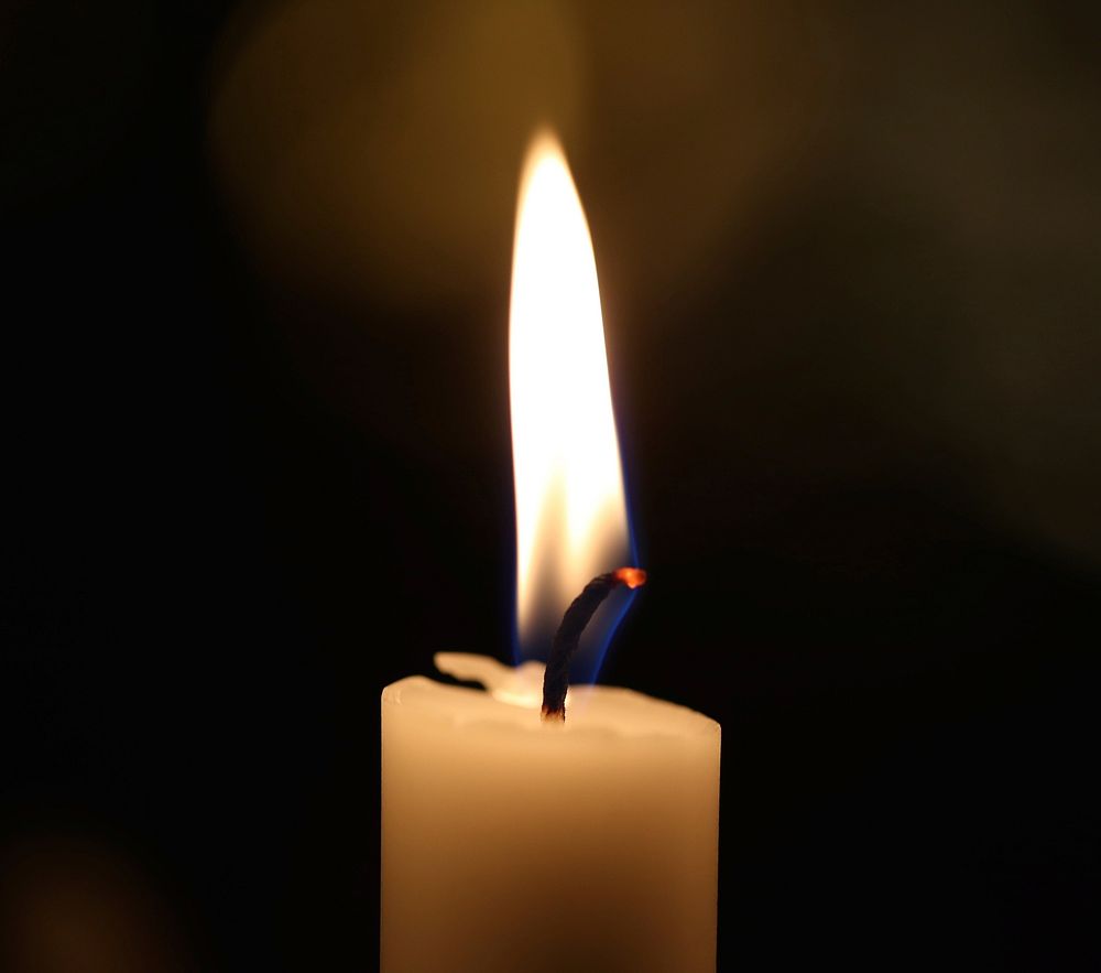 Burning candle in the dark. Free public domain CC0 image.