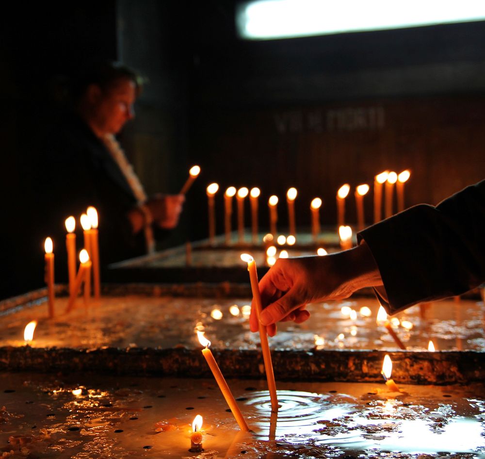 Lighting a candle in church. Free public domain CC0 image.