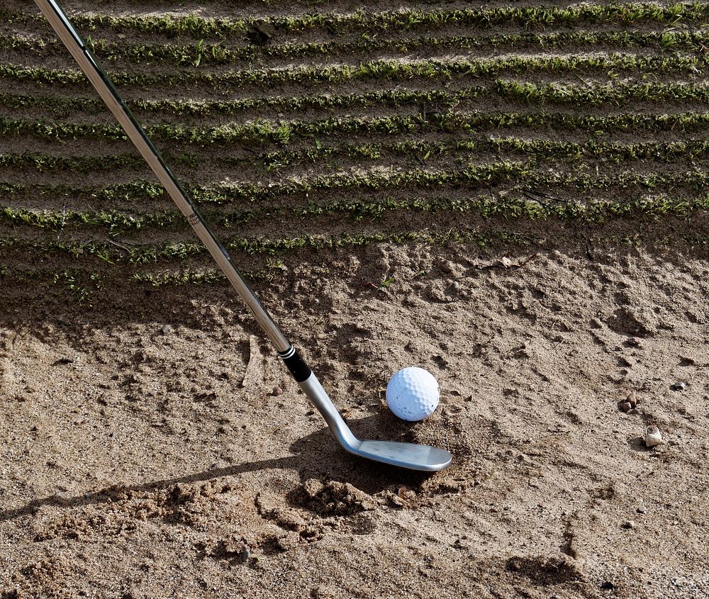 Closeup on golf club head and ball in soil. Free public domain CC0 image.