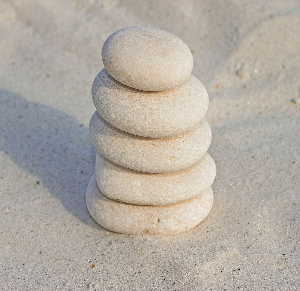 Balancing rock piles on beach sand. Free public domain CC0 photo