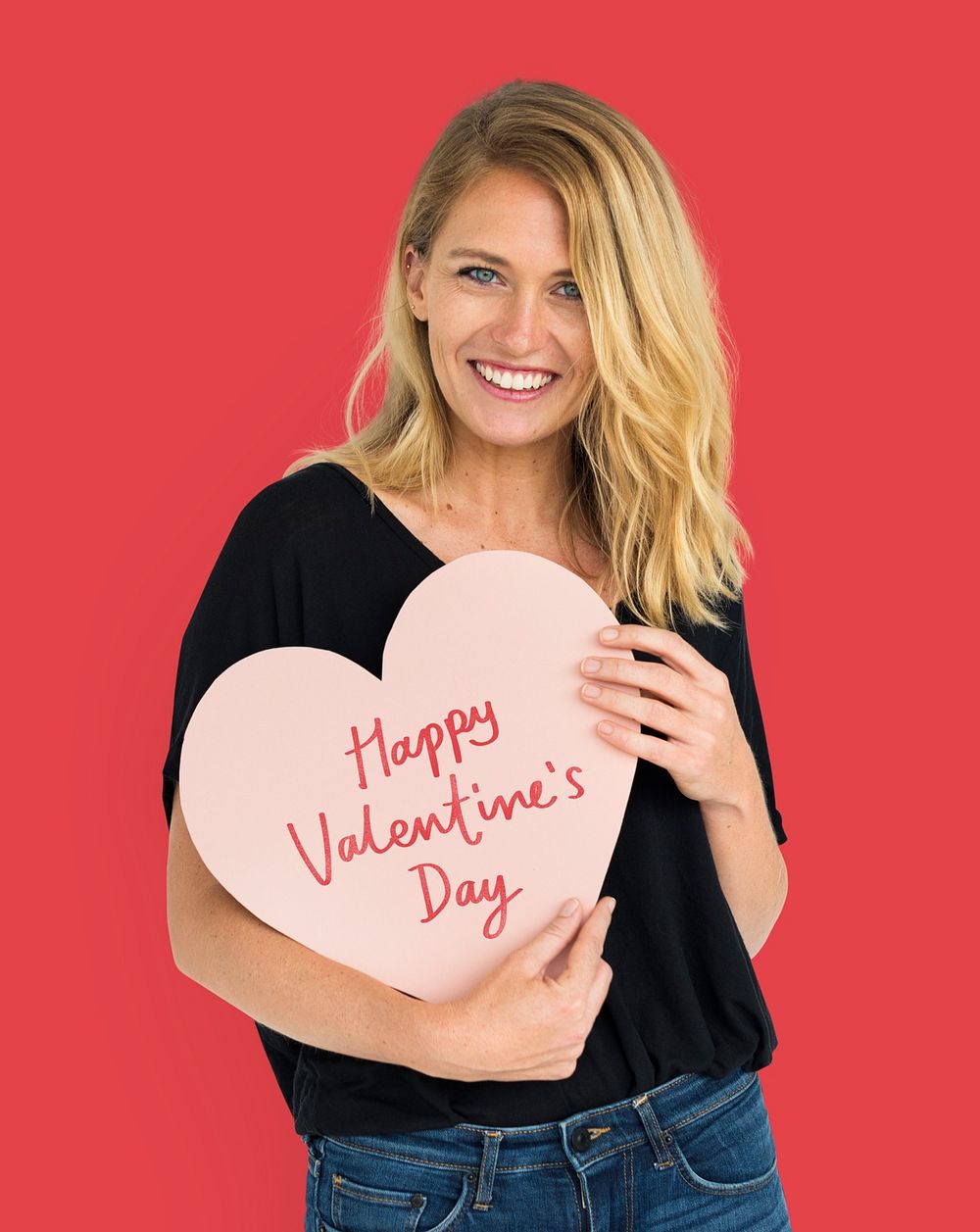 Cheerful woman holding a valentine's day heart