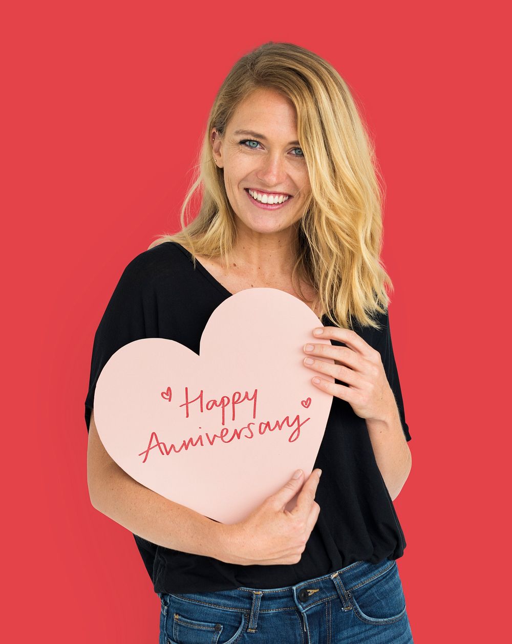 Cheerful woman holding a Happy Anniversary heart