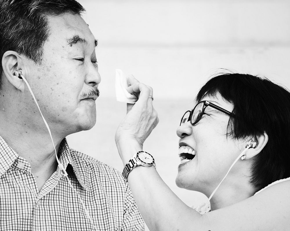 Senior Asian couple listening to music together