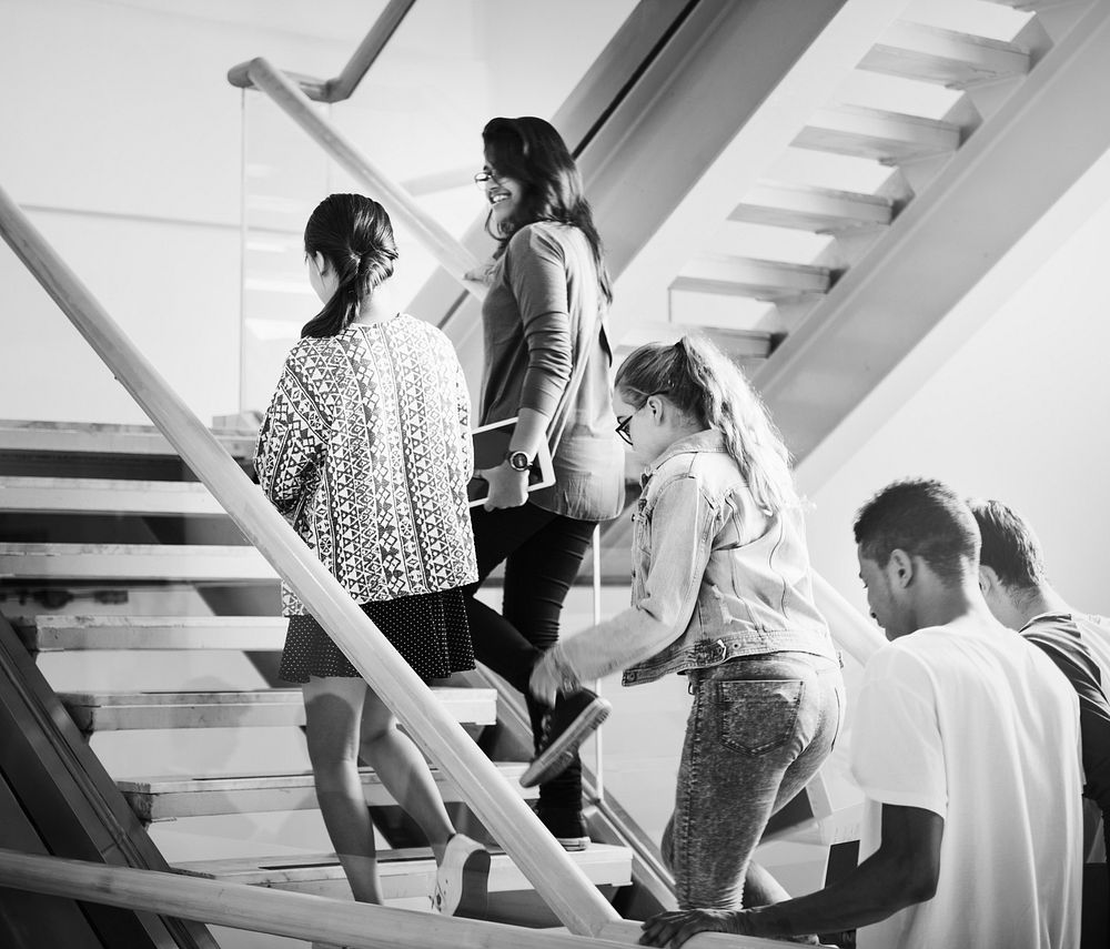 Group of teen students walking up the staircase