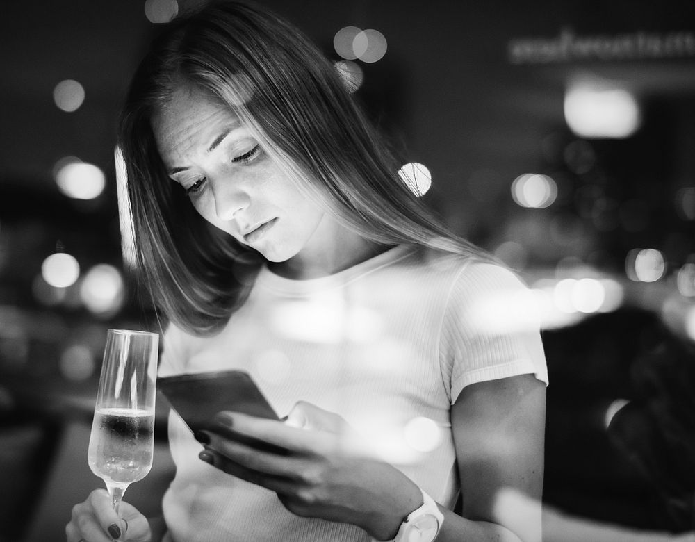 Woman using a smartphone at a rooftop bar
