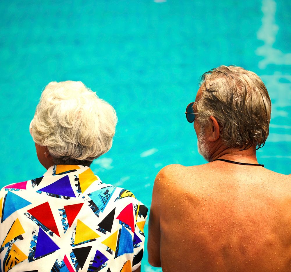Senior couple sitting by the pool