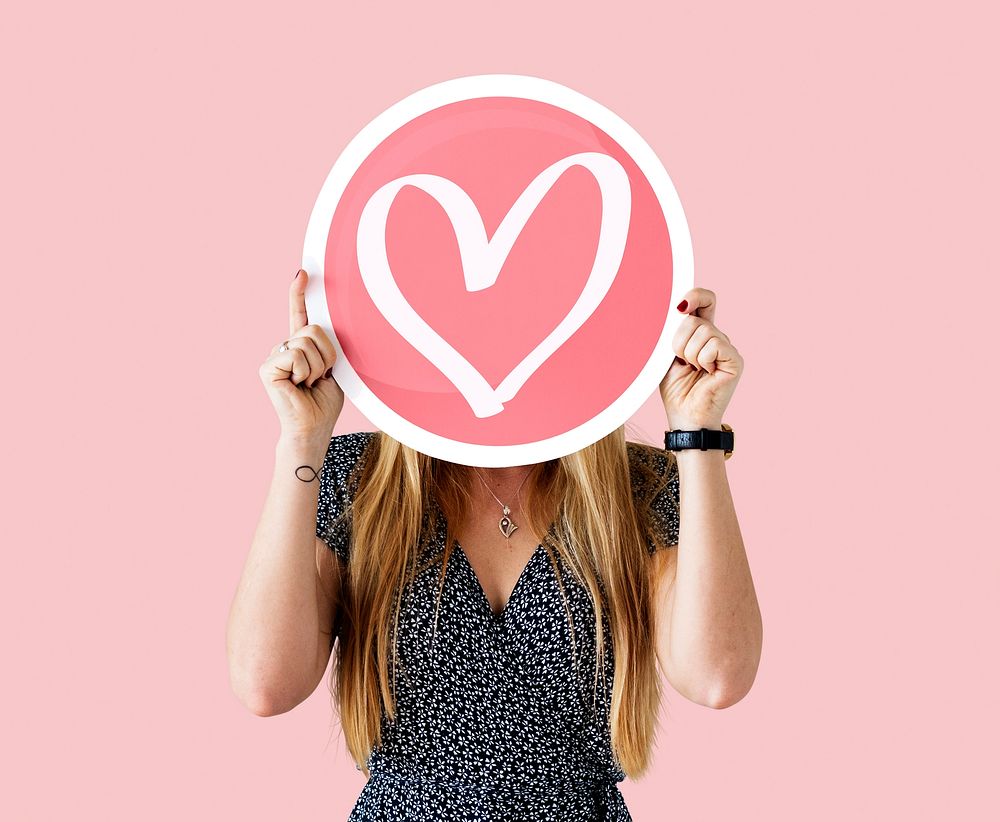 Cheerful woman holding heart icon
