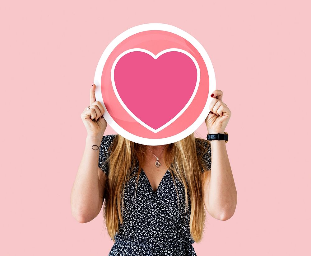 Cheerful woman holding heart icon