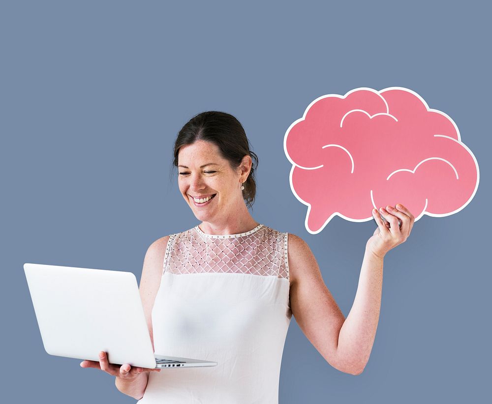 Woman holding a brain icon and using a laptop