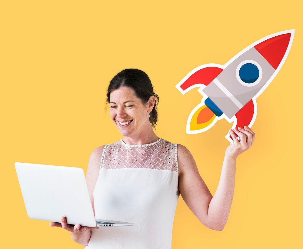 Woman holding a rocket and using a laptop