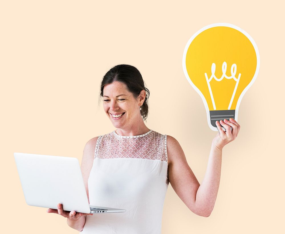 Woman holding an idea icon and using a laptop