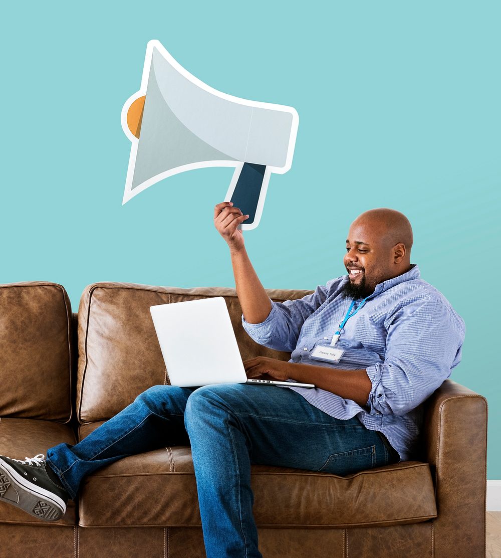 Man showing megaphone icon on couch