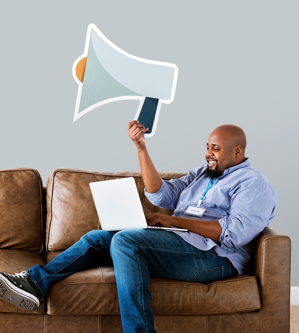 Man showing megaphone icon on couch