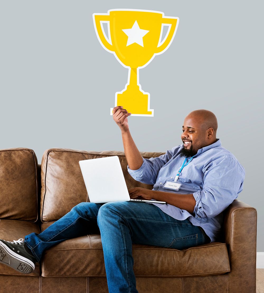 Man showing trophy icon on couch