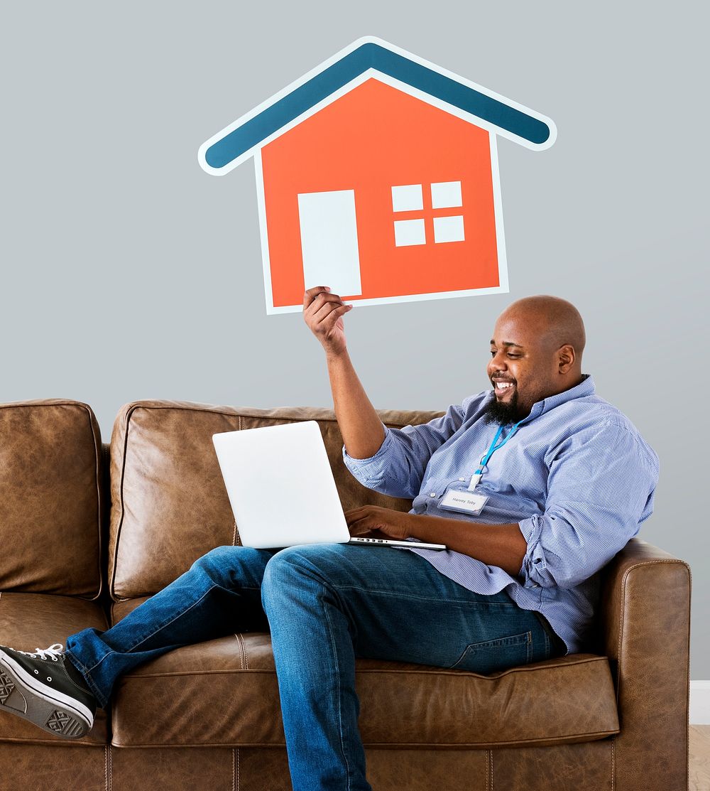 Man showing house icon on couch