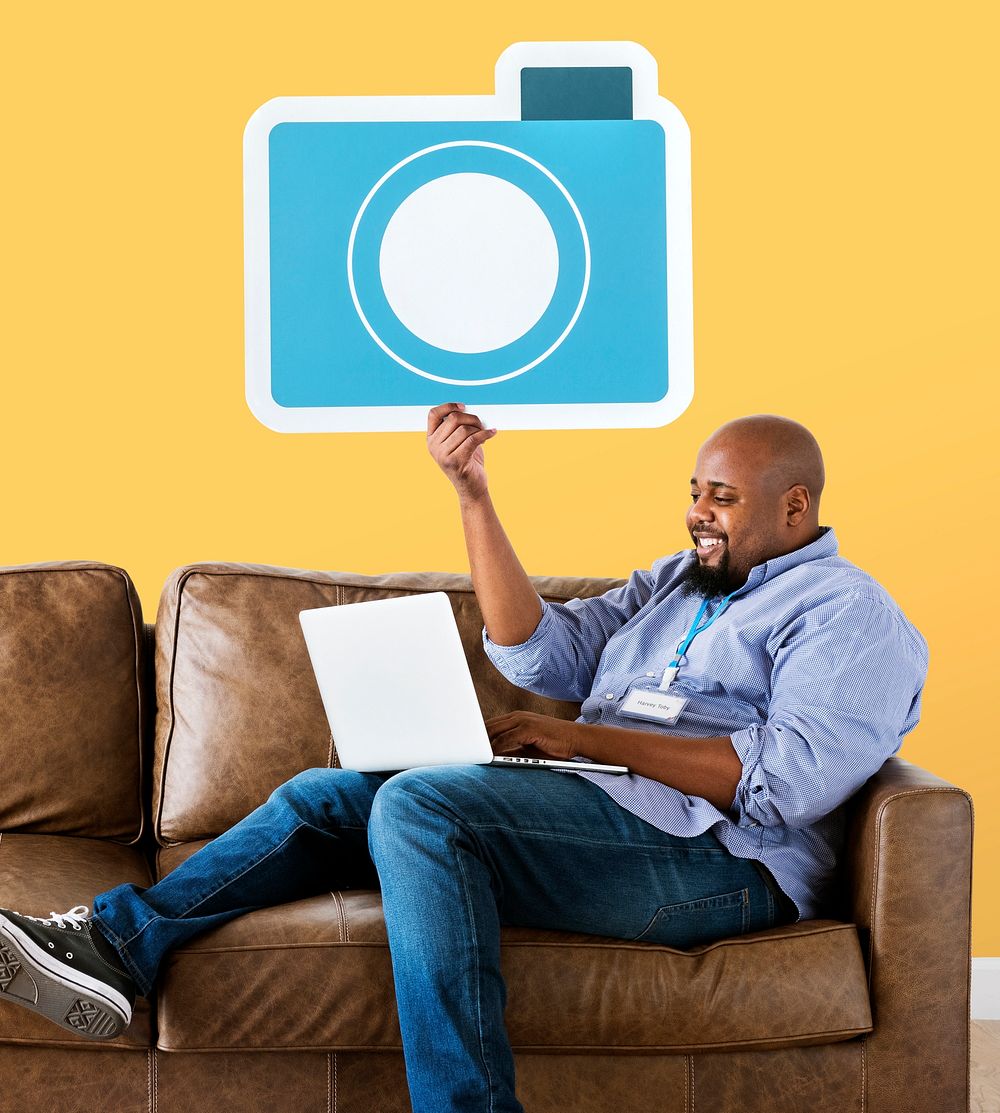 Man holding a camera icon on couch