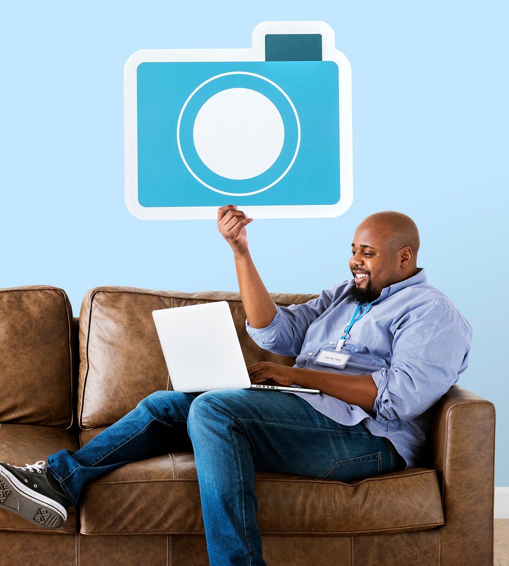 Man holding a camera icon on couch