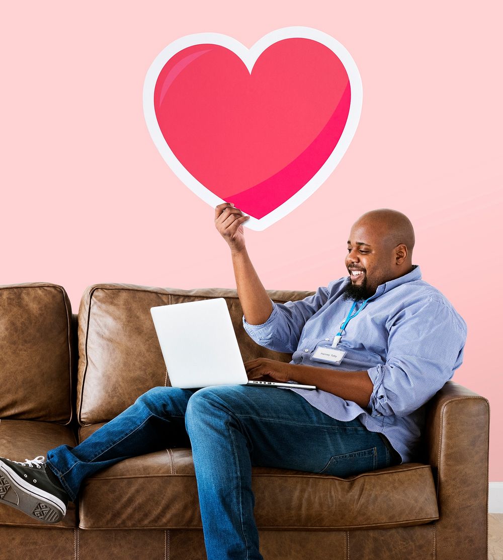Man showing a heart icon on couch