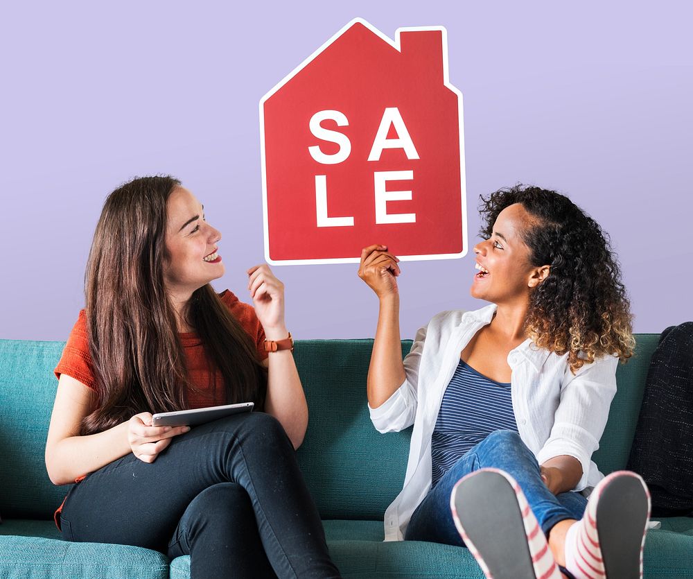 Cheerful women holding a house sales icon
