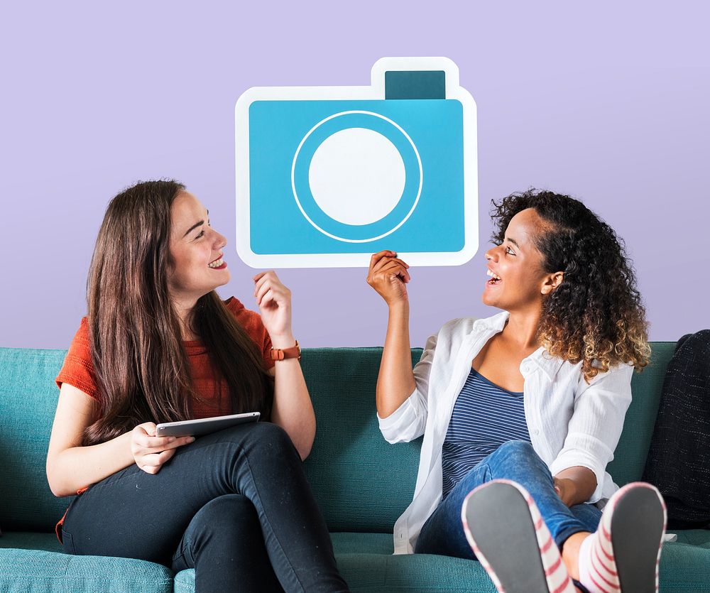 Cheerful women holding a blue camera icon