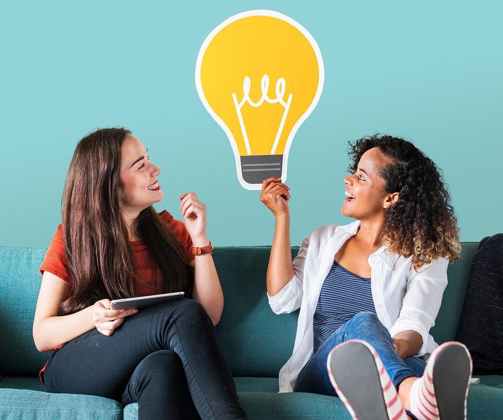 Women holding a light bulb icon on couch