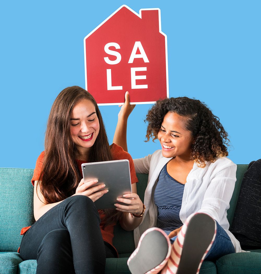 Women holding a house sales icon and using a tablet