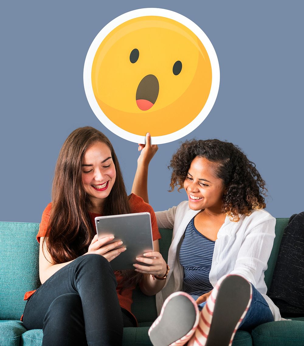 Women showing surprise emoticon and using tablet