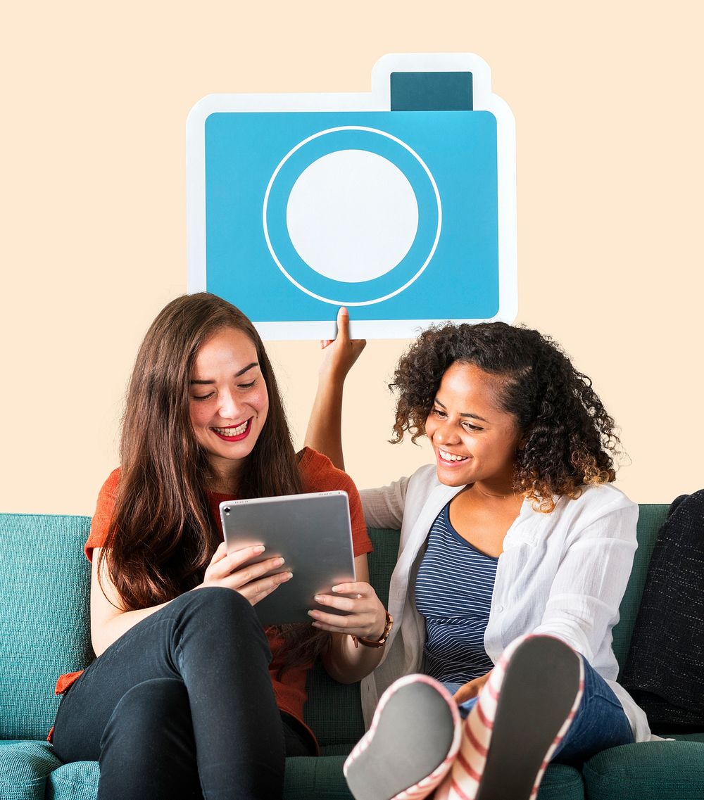 Women holding a camera icon and using a tablet
