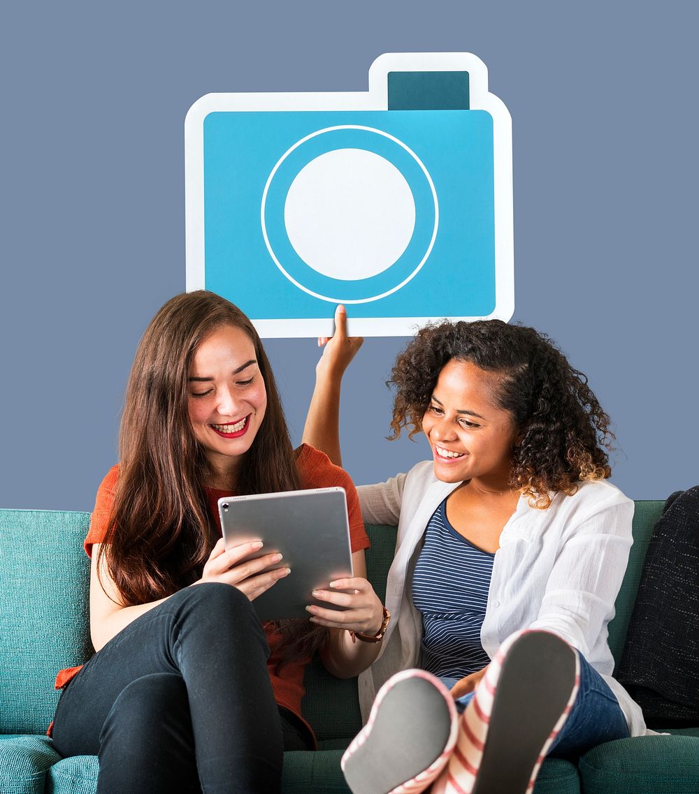 Women holding a camera icon and using a tablet