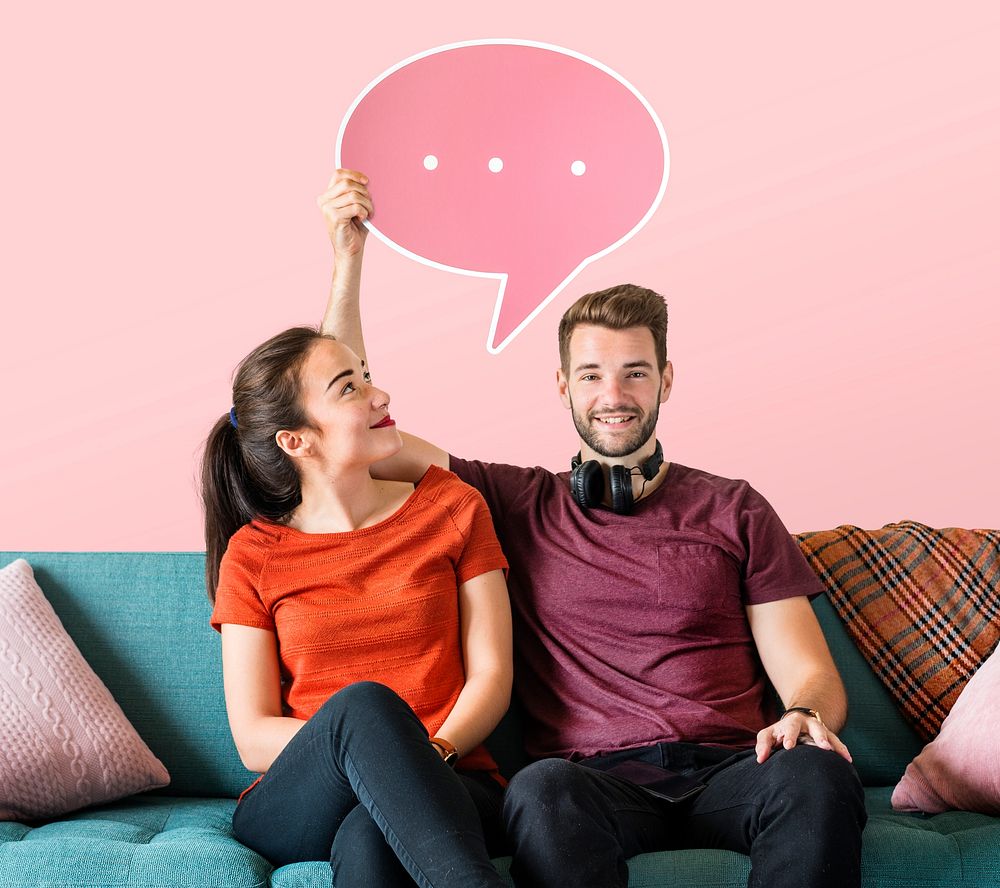 Cheerful couple holding a pink speech bubble icon