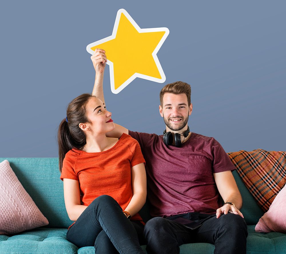 Cheerful couple holding a golden star icon