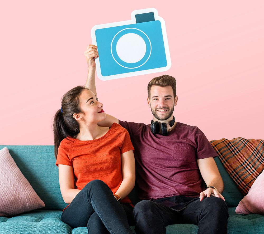 Cheerful couple holding a camera icon