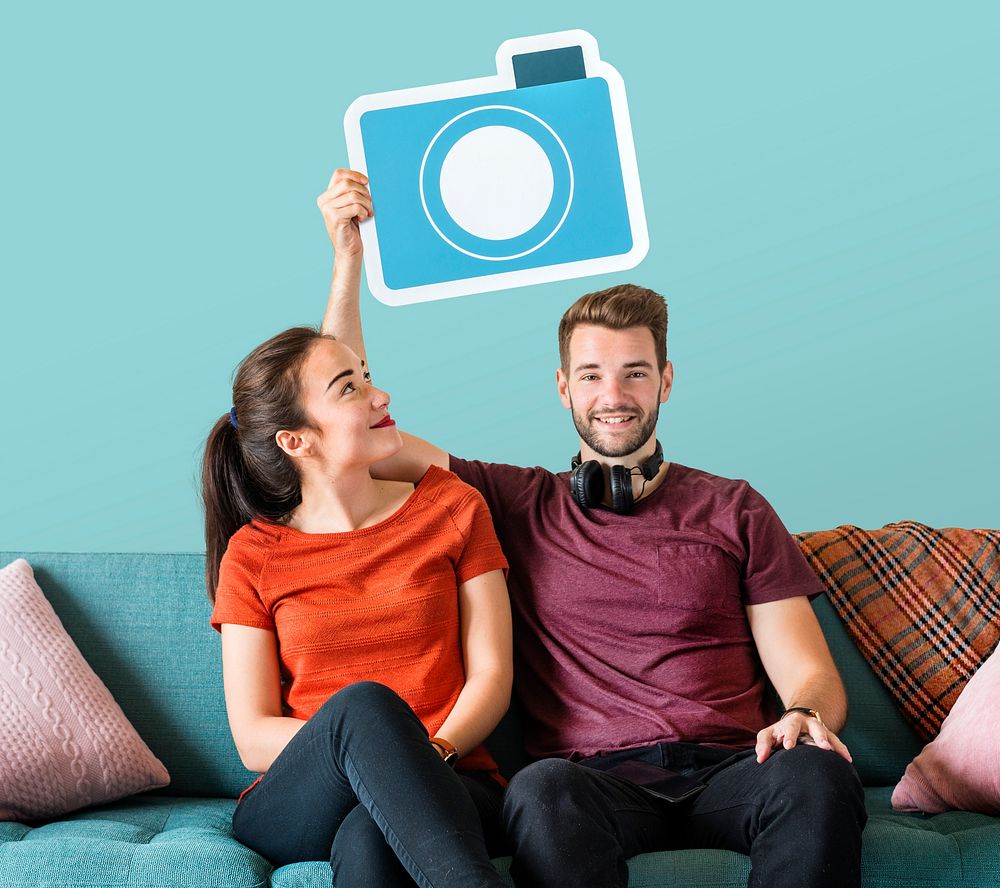 Cheerful couple holding a camera icon