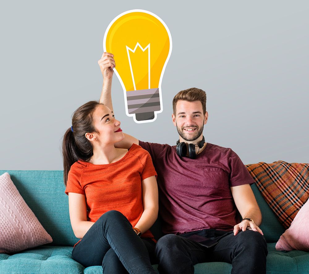 Cheerful couple holding a light bulb icon