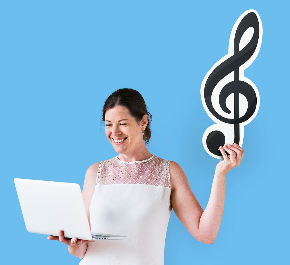 Woman holding a musical note clef and a laptop