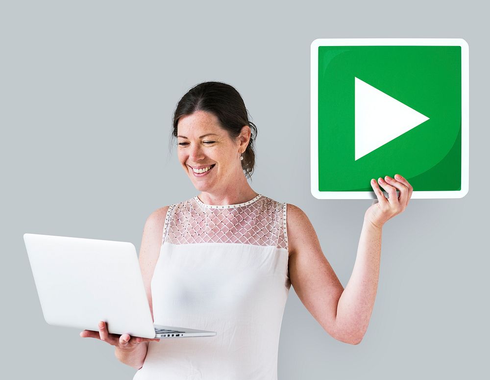 Woman holding a play button and a laptop
