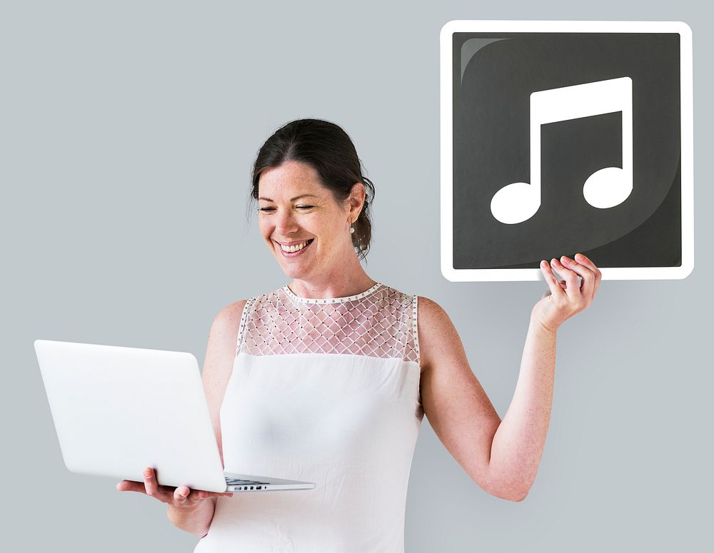 Woman holding a music icon and a laptop