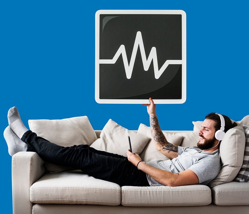 Male on a couch holding a frequency icon