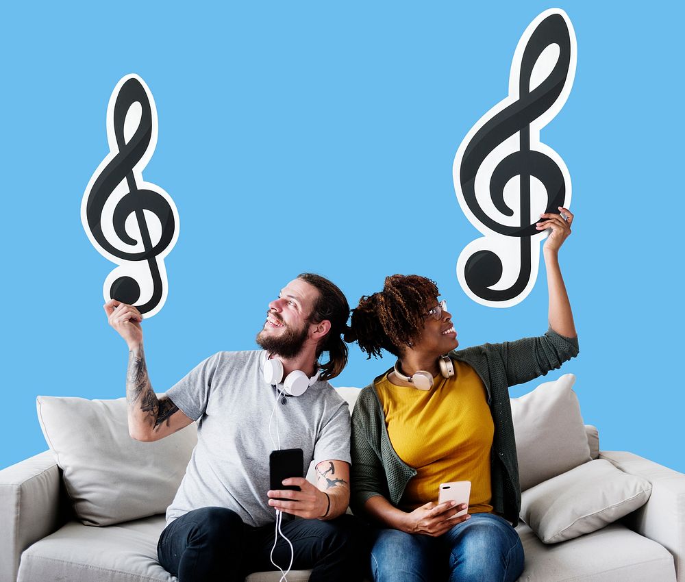 Interracial couple on a couch holding  musical note icons