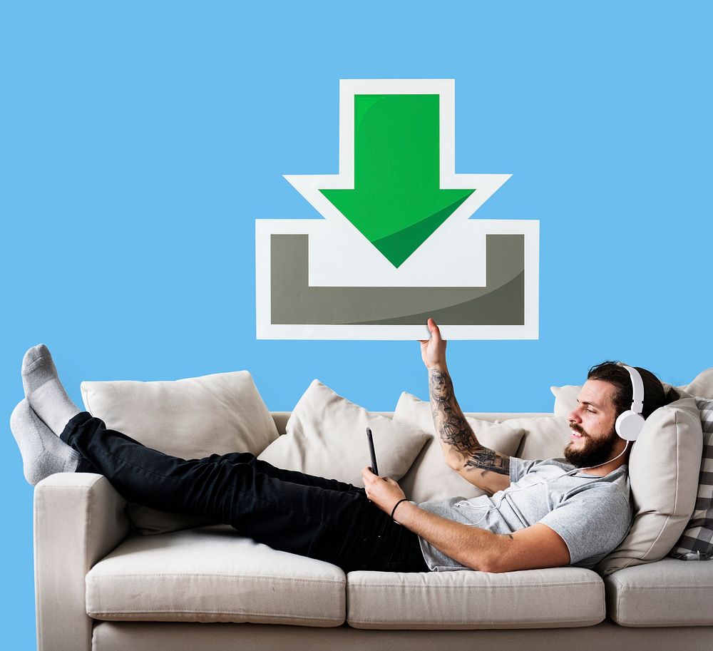 Male on a couch holding a download icon
