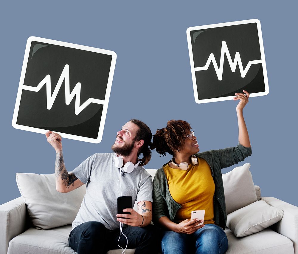 Interracial couple on a couch holding frequency icons