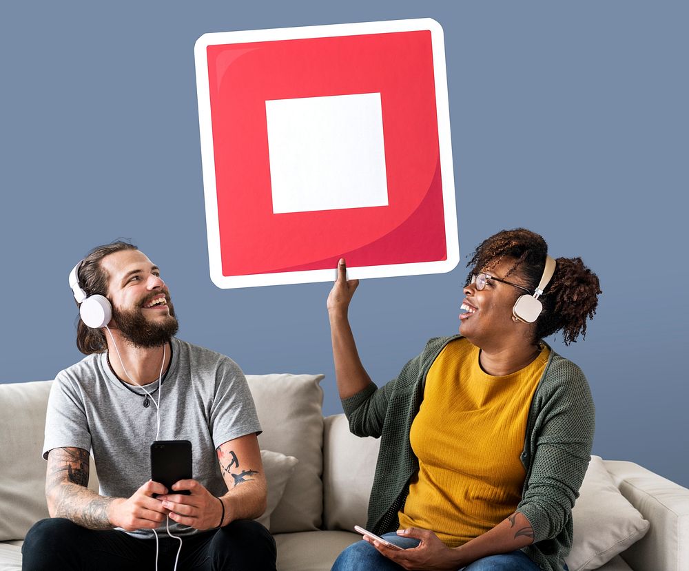 Interracial couple listening to music and holding a stop button
