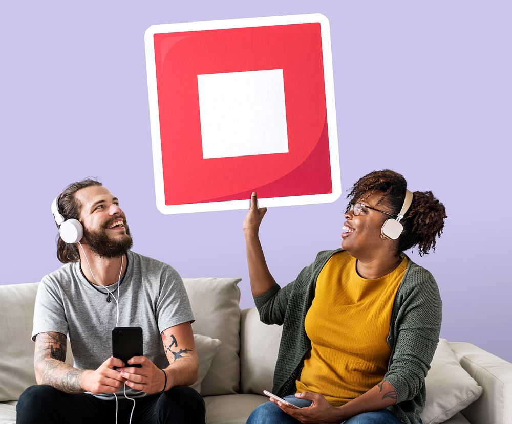 Interracial couple listening to music and holding a stop button